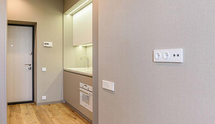 Clean interior wall featuring electrical outlets and switches
