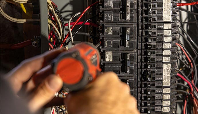Electrician installing a circuit breaker.