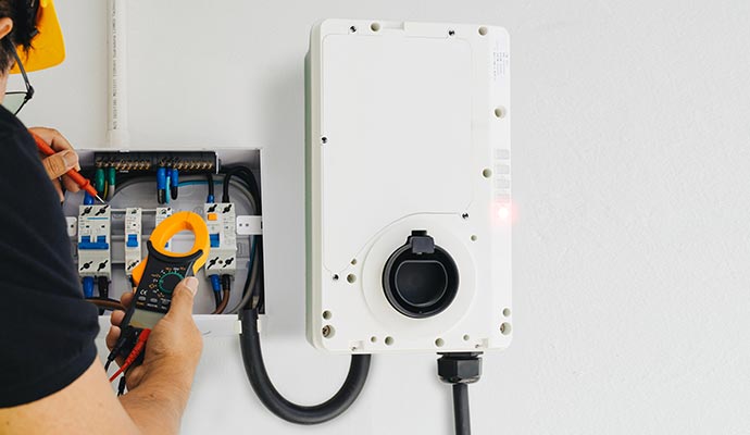 Electrician testing a panel for an EV charger installation.