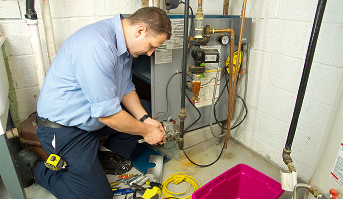 An expert repairing a gas furnace