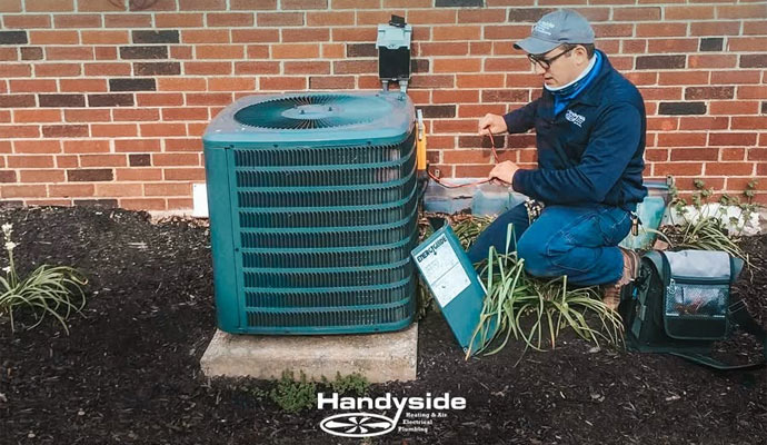 Handyside technician servicing an outdoor American Standard AC unit