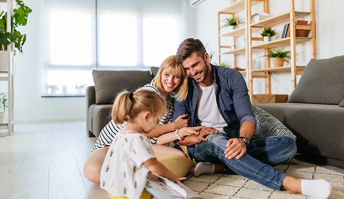 Happy family smiling with daughter in living room