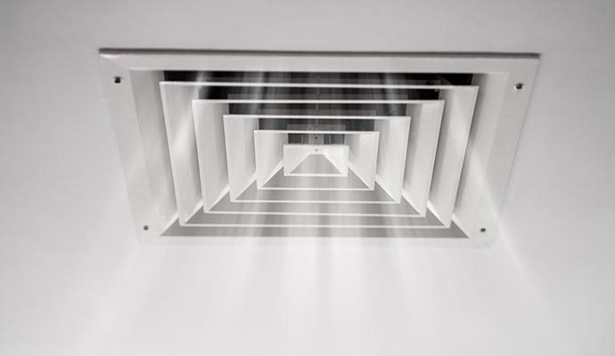 Square ceiling diffuser vent releasing clean airflow into a room