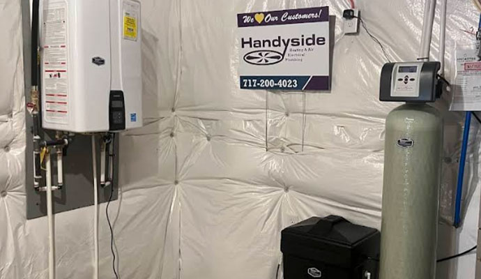 Tankless water heater and water softener system installed in a utility room