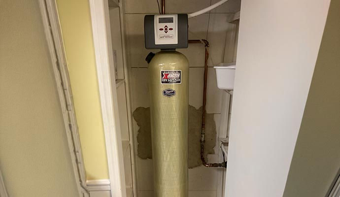 Installed water softener system with a digital control head in a utility closet