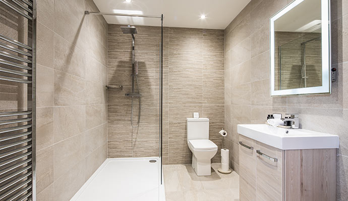 Modern remodeled bathroom with walk-in shower, tiled walls, and vanity