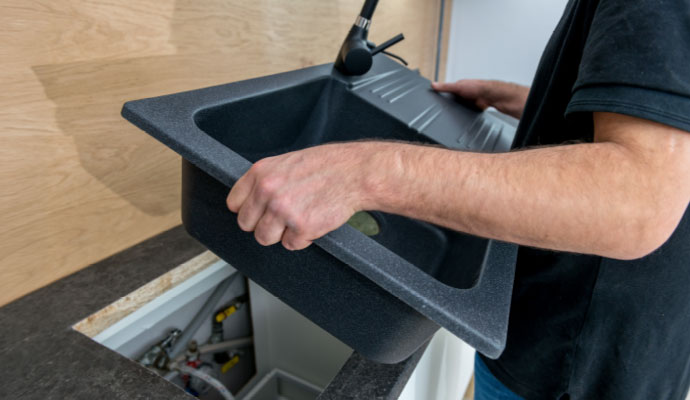 Technician installing a modern kitchen sink