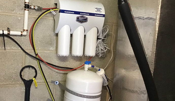 Reverse osmosis water filtration system with storage tank mounted on a wall