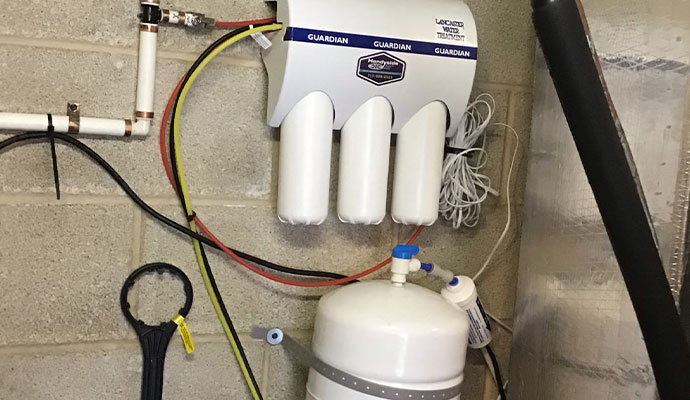 Reverse osmosis water filtration system with storage tank mounted on a wall