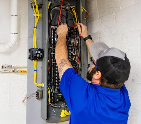Electrician testing a main home electrical panel box.
