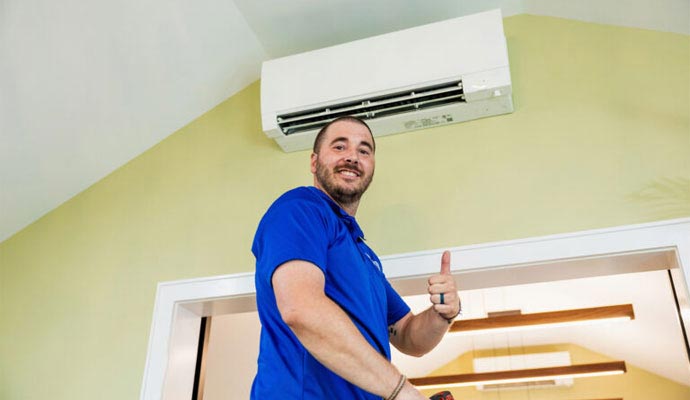 Technician giving thumbs up after AC installation.