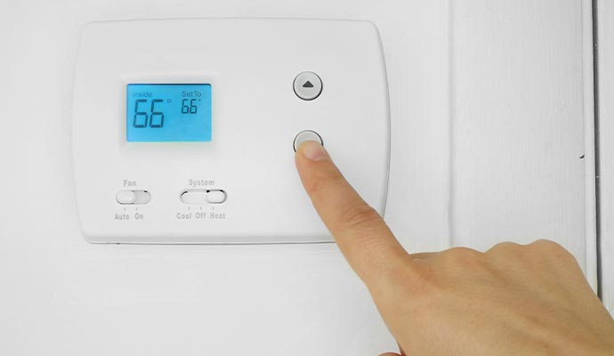 Person controlling indoor temperature using a thermostat