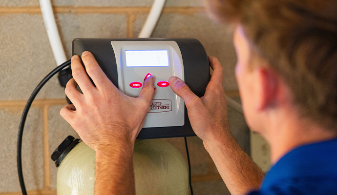 Technician adjusting water softener control valve