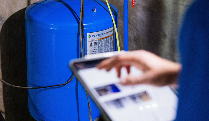 Technician inspecting well water pressure tank