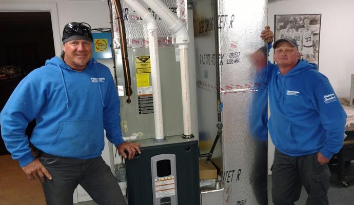 Expert technicians posing with an installed furnace system